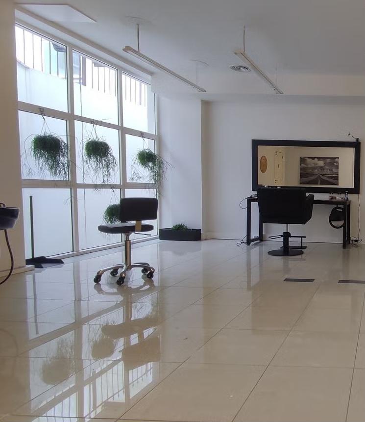 Salão Hair Core, amplo e luminoso, com plantas suspensas à janela